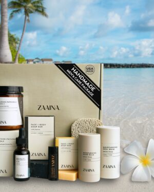 ZAAINA Men's Self Care Package featuring handmade natural grooming products, including a soy candle, soap bars, serum, hand balm, and heel balm, set against a beach background.