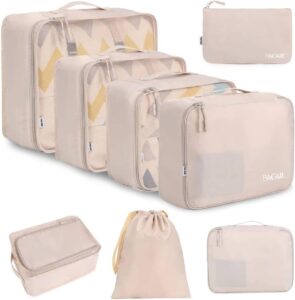 A flat lay view of the cream-colored BAGAIL 8 Set Packing Cubes, neatly organized with clothes and travel accessories inside.